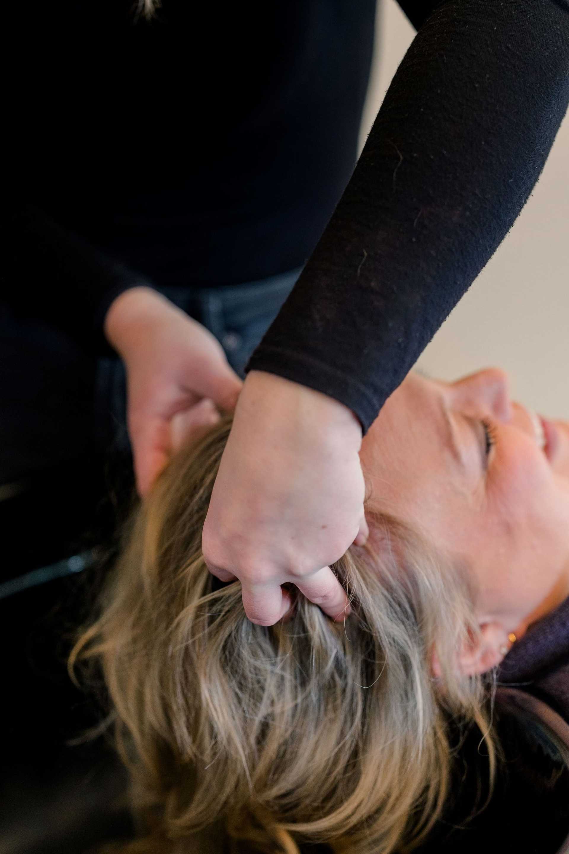 Person receiving a relaxing head massage with hands gently massaging their scalp.