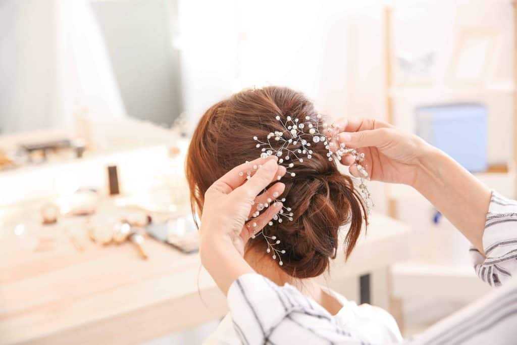 Hair styled with delicate floral accessories in a cozy dressing room setting.